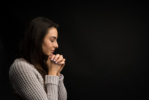side profile of a woman praying 