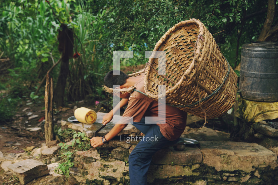 a boy gathering crops with a basket on his back 