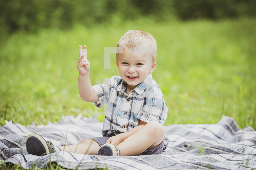toddler sitting on a blanket in the grass