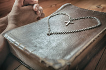 cross necklace in the shape of a heart on a Bible 