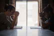 men praying in front of a window at a Bible study 