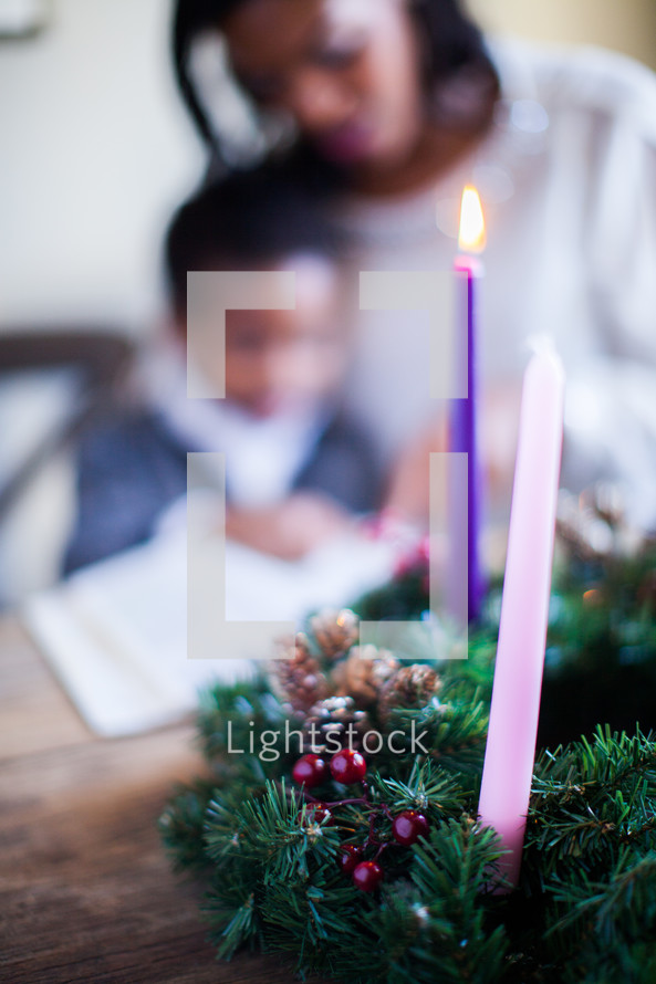 mother and son reading a Bible near an Advent wreath 