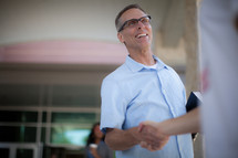man welcoming and shaking hands at a church entrance 