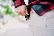 a man pulling his wallet out of his back pocket 