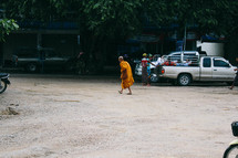 a monk walking across a parking lot 