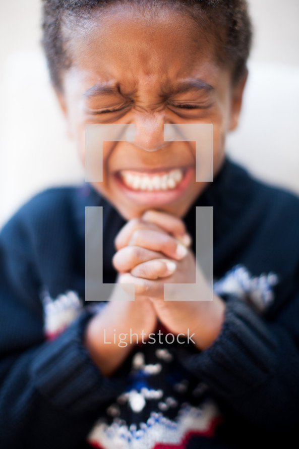 a boy child with praying hands 