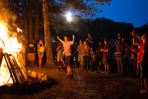teens gathered around a bonfire 