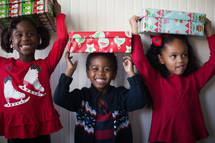 siblings holding wrapped Christmas gift 