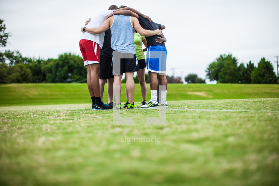 team prayer on a sports field 