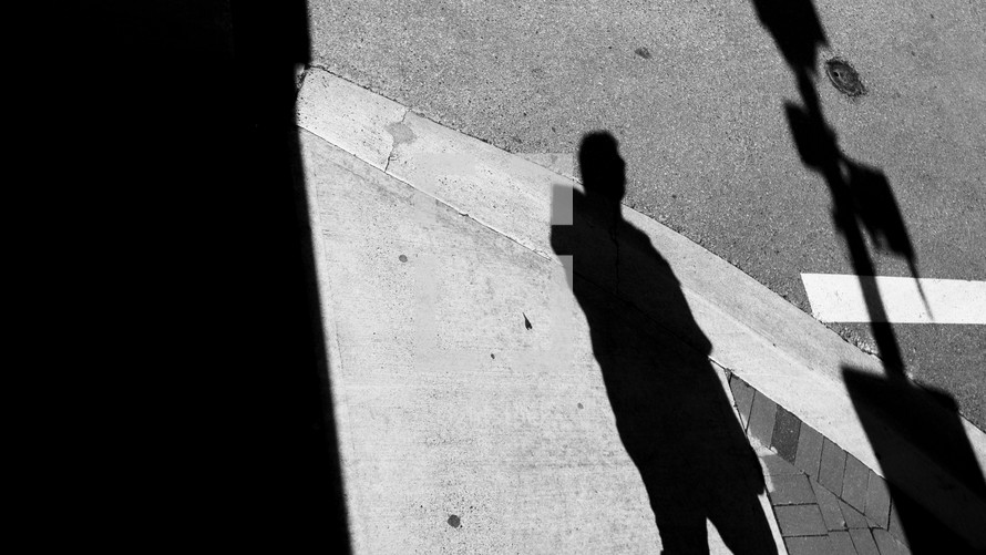 shadow of a man on a sidewalk 