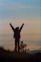 Hiker celebrates arriving at the top of Hadley mountain in the Adirondacks of upstate New York