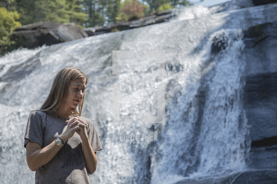 praying in front of a waterfall in Asheville, NC 