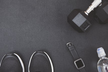 weights, sneakers, smartwatch fitness tracker, and water bottle 