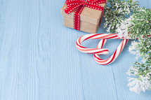candy canes, gift box, and Christmas greenery on blue 