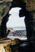View seen through a hole in a rock wall.