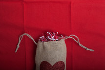 confetti in a burlap sac with a heart 