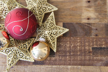 Christmas ornaments, stars and baubles on a wood floor background
