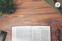 open Bible and reading glasses on a wood table - James 