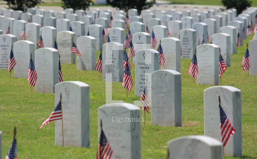 American flags and grave markers in a cemetery 