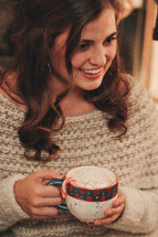 happy woman holding a mug of hot cocoa 