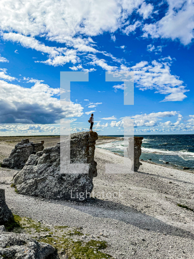 a man standing on a rocky shore 