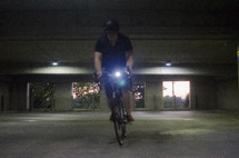 man riding a bicycle in a parking garage 