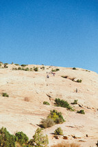 people hiking up the side of a mountainside 