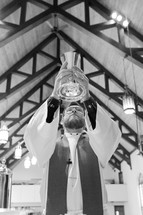priest holding up a communion chalice 