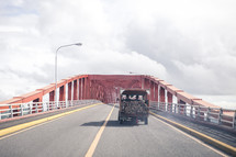 truck carrying boards crossing a bridge 