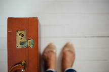 woman's feet and a suitcase 