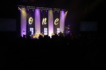 The word one on a stage at a contemporary worship service. 