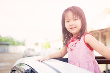 Little girl in the car looking out a sunroof.