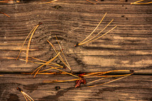pine straw on a wood deck 