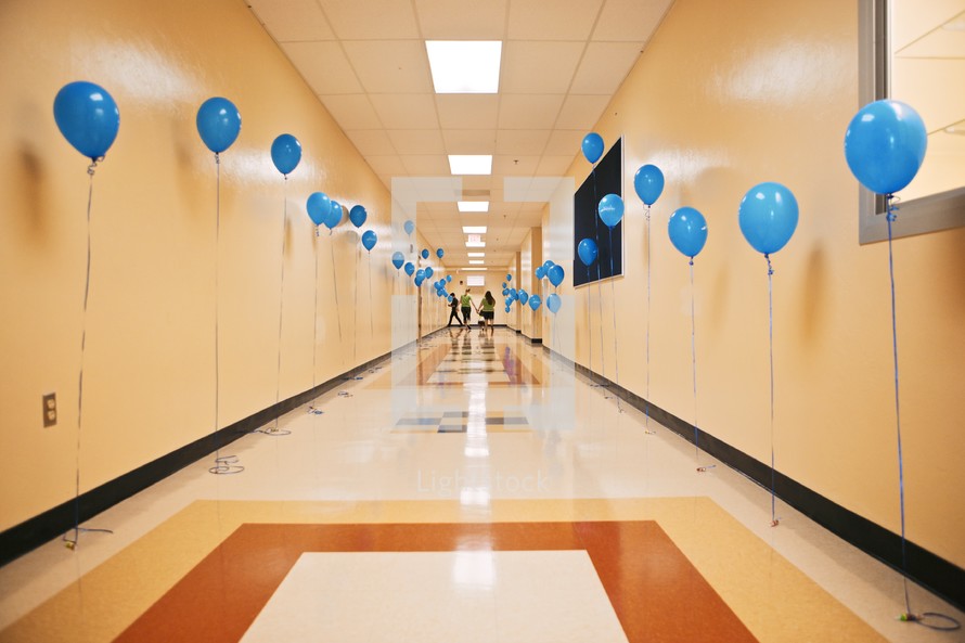 A hallway lined with blue balloons.