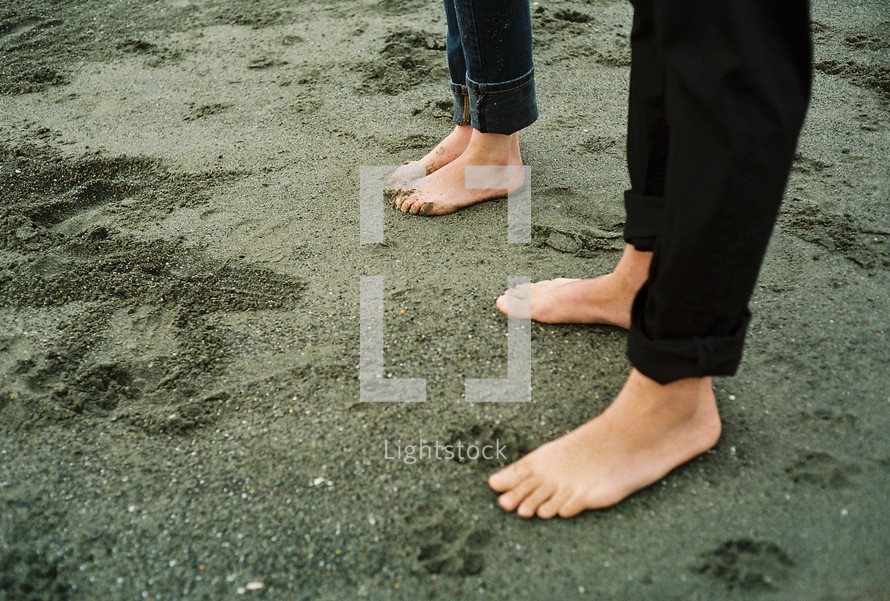 Barefoot couple in sand