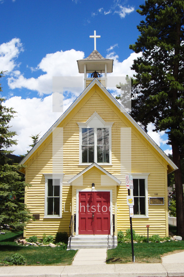Small yellow church with red doors