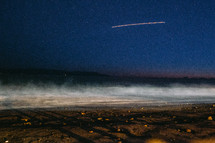 streak in the sky above a beach 