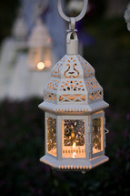 candle burning in a white lantern