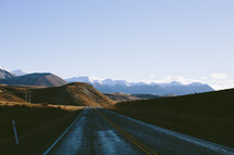 A highway leading toward a mountain range.