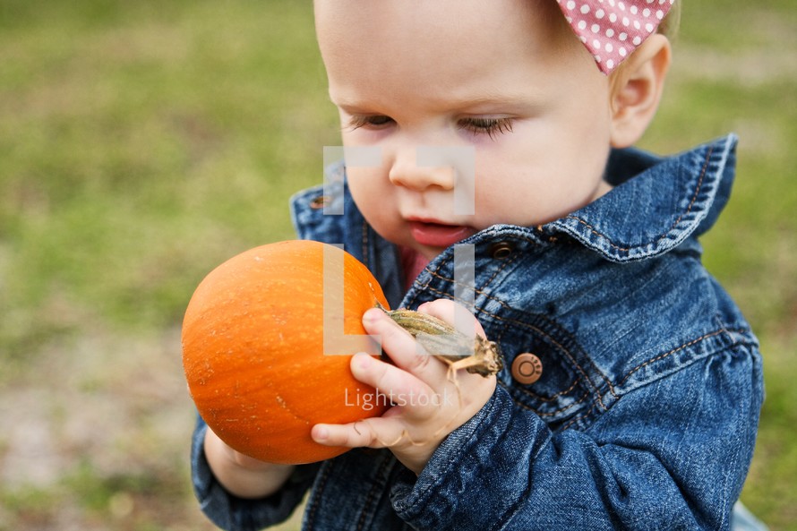 Child holding a pumpkin