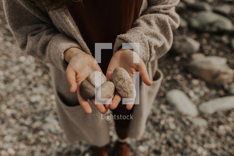 cupped hands holding stones 