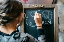 woman writing on a chalkboard 