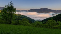 Sunrise in green nature landscape with foggy clouds in mountains valley in spring morning Time lapse
