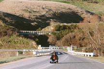 A person sitting in the middle of a highway.