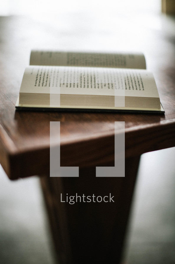 Open bible sitting on wooden pulpit