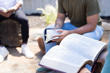 A small group Bible study sitting together outdoors. 