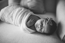 swaddled newborn on a chair 