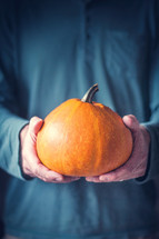 man holding a pumpkin with both hands 