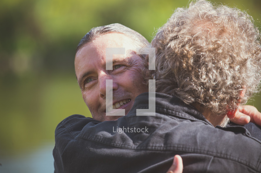 men hugging after being baptized 