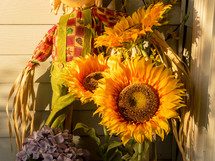 sunflowers and scarecrow on a porch in fall 
